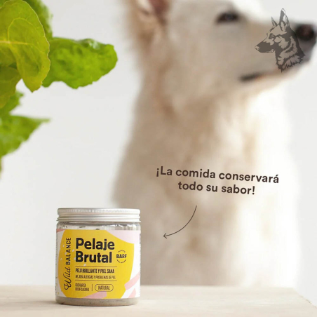 Un frasco de "Pelaje Brutal" sobre una mesa con un fondo desenfocado donde se observa un perro blanco. Texto sobreimpreso: "¡La 