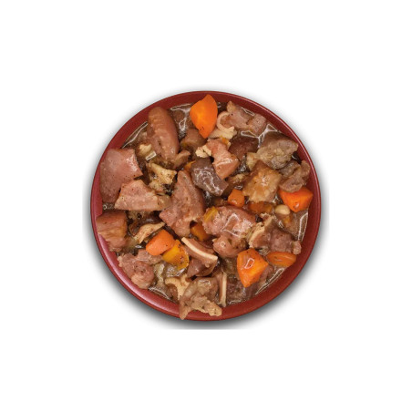 Guiso natural con orejas de cerdo troceadas, zanahoria y salsa, servido en plato para perros.