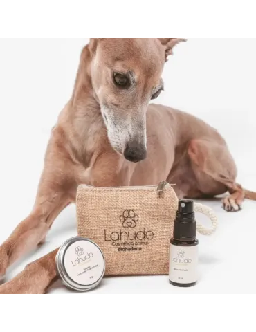 Galgo junto al neceser de Lahude, bálsamo hidratante regenerador y spray reparador en tamaño mini.