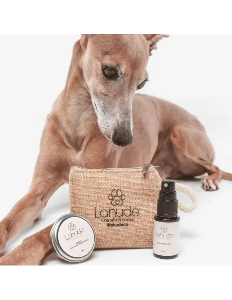 Galgo junto al neceser de Lahude, bálsamo hidratante regenerador y spray reparador en tamaño mini.
