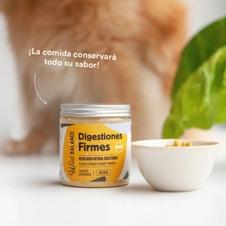 Bote de Digestiones Firmes Wild Balance junto a cuenco de comida con un perro de fondo; suplemento que mantiene el sabor del ali