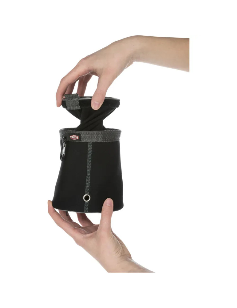 Persona mostrando cómo extraer el compartimento interior de la bolsa porta premios Trixie negra.