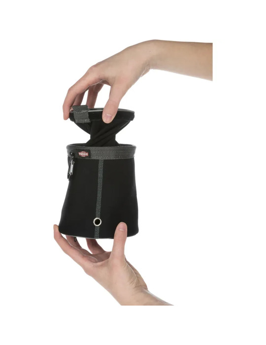 Persona mostrando cómo extraer el compartimento interior de la bolsa porta premios Trixie negra.