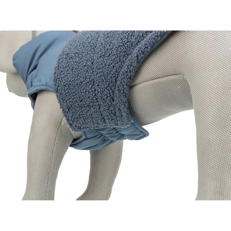 Detalle del abrigo Trixie Ajou azul para perro, mostrando costado acolchado y ajuste bajo el abdomen