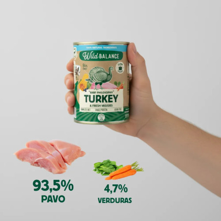 Persona sujetando una lata de comida húmeda para perros Wild Balance de pavo con verduras frescas, destacando sus ingredientes n
