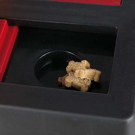 Primer plano del compartimento del Dog Activity Chess con snacks en forma de hueso para perros, parte del juego de inteligencia 