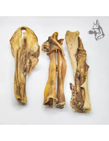 Tres piezas de caravaca de cabra deshidratada con diferentes formas y texturas, ideales como snack duradero para perros.